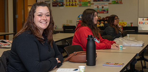 Student smiling at desk